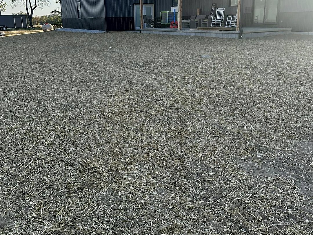 Compacted stone apron in front of an open equipment shop