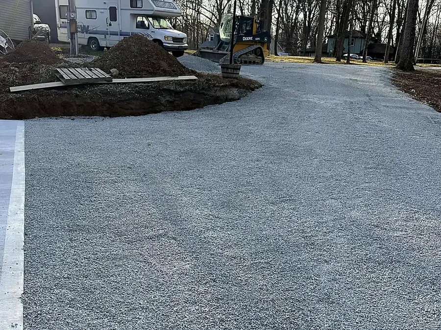Freshly spread and rolled driveway stone running between mature trees
