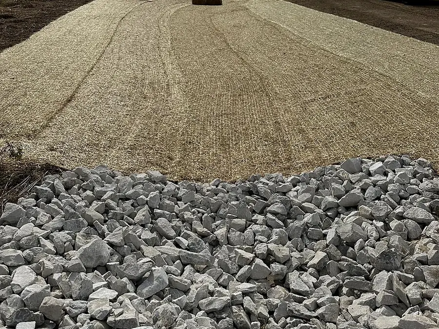 Pile of clean driveway stone staged on a graded pad ready to spread