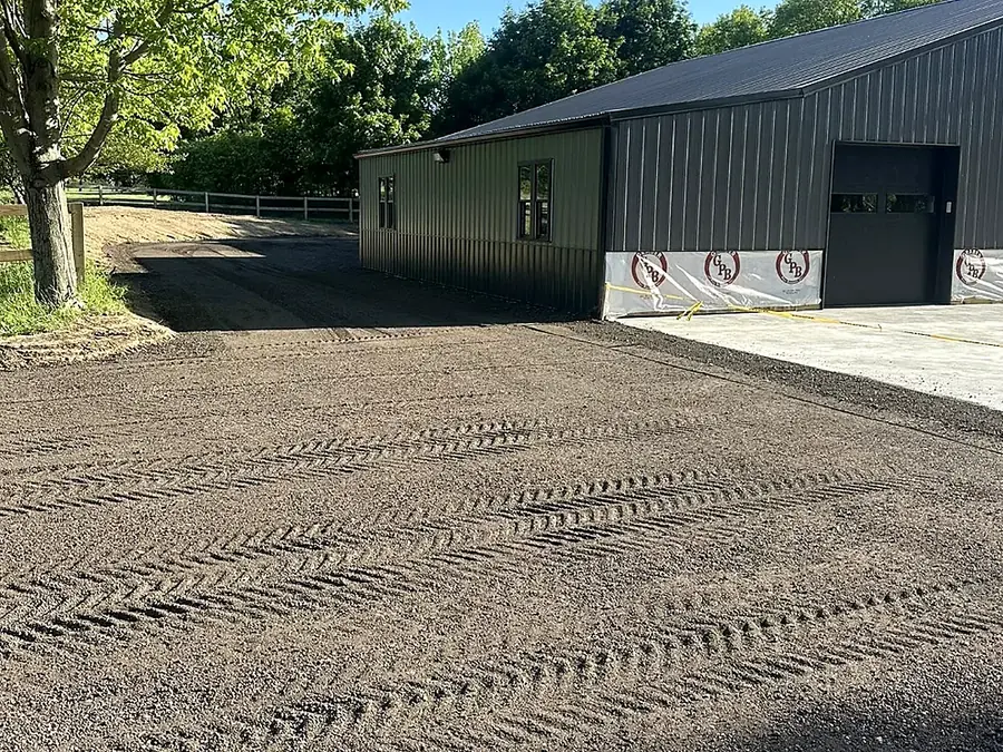 Compacted and tracked base prepared for a concrete apron pour