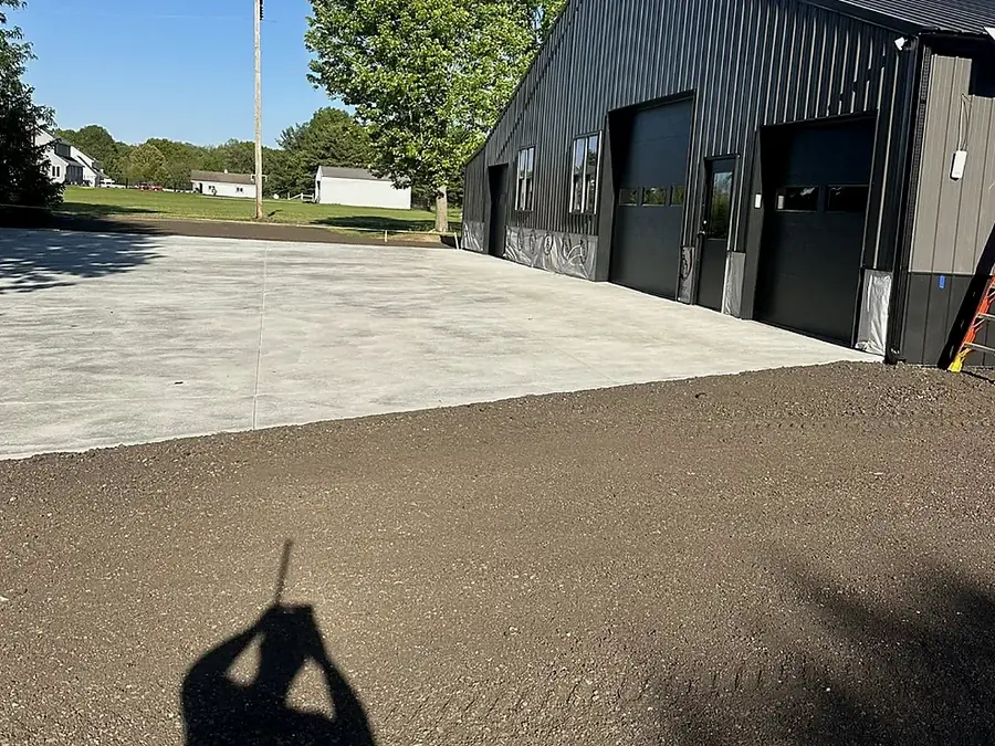 Finished concrete slab poured in front of a metal building