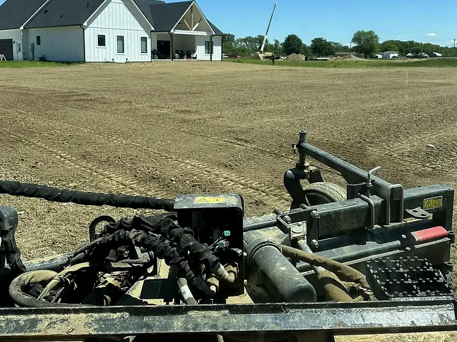 Tracked machine with a finish attachment working a levelled yard