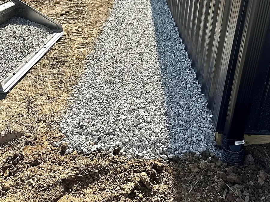 Clean stone edge and finished grade running along a metal building